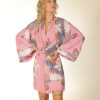 Mulher loira usando um vestido curto manga longa amarração na cintura estampa exclusiva pavão pink praticidade leveza conforto elegância maria sanz kimono quimono