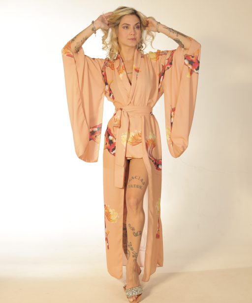 Mulher loira usando um kimono longo manga longa faixa na cintura estampa exclusiva com carpas laranja leveza conforto praticidade elegância maria sanz kimono quimono