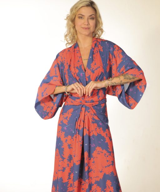 Mulher loira usando um vestido longo manga curta com amarração na cintura estampa exclusiva laranja com azul elegância praticidade conforto leveza maria sanz kimono quimono
