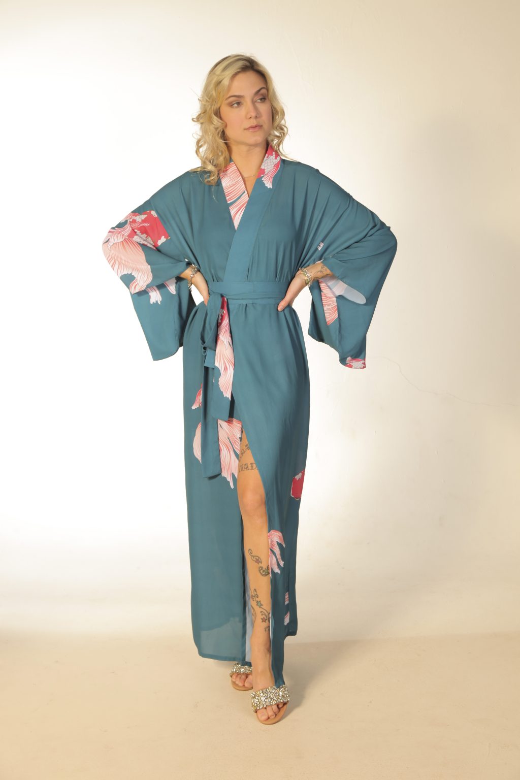Mulher loira usando um kimono longo manga longa faixa na cintura estampa exclusiva com carpas leveza conforto praticidade maria sanz kimono quimono