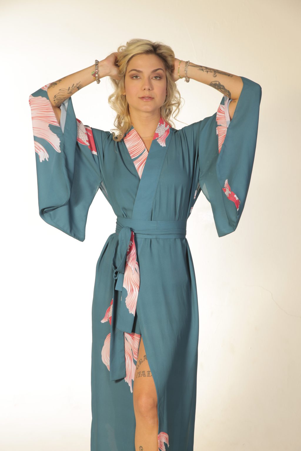 Mulher loira usando um kimono longo manga longa faixa na cintura estampa exclusiva com carpas leveza conforto praticidade maria sanz kimono quimono