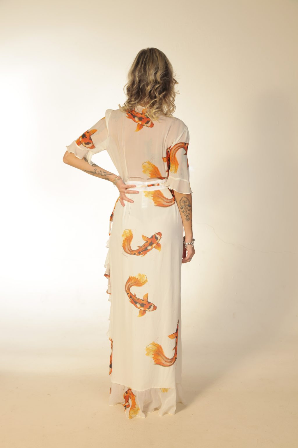 Mulher loira usando um vestido longo transpassado manga curta 100% seda estampa de carpas laranja exclusiva desenvolvida por maria sanz kimono quimono leveza praticidade conforto elegância