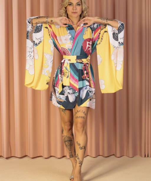 Mulher loira usando um kimono curto manga longa faixa na cintura estampa exclusiva rainbow terceira peça leveza conforto praticidade maria sanz kimono quimono