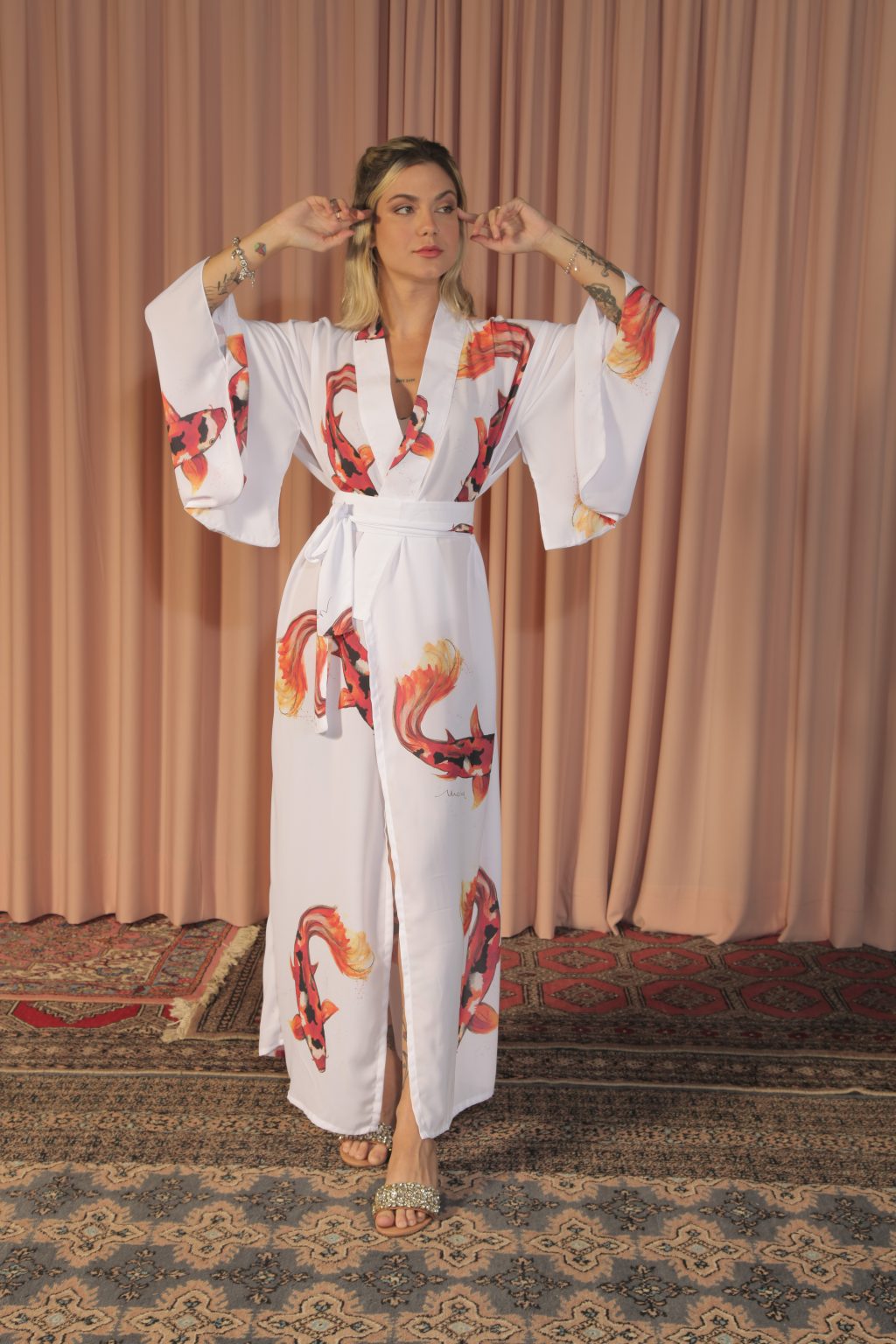 Mulher loira usando um kimono longo manga longa faixa na cintura estampa exclusiva branco com carpas leveza conforto praticidade maria sanz kimono quimono