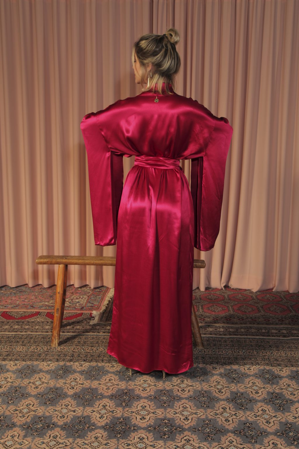 Mulher loira usando um kimono longo manga longa vermelho viscose faixa de amarração na cintura leveza elegância praticidade conforto maria sanz kimono quimono