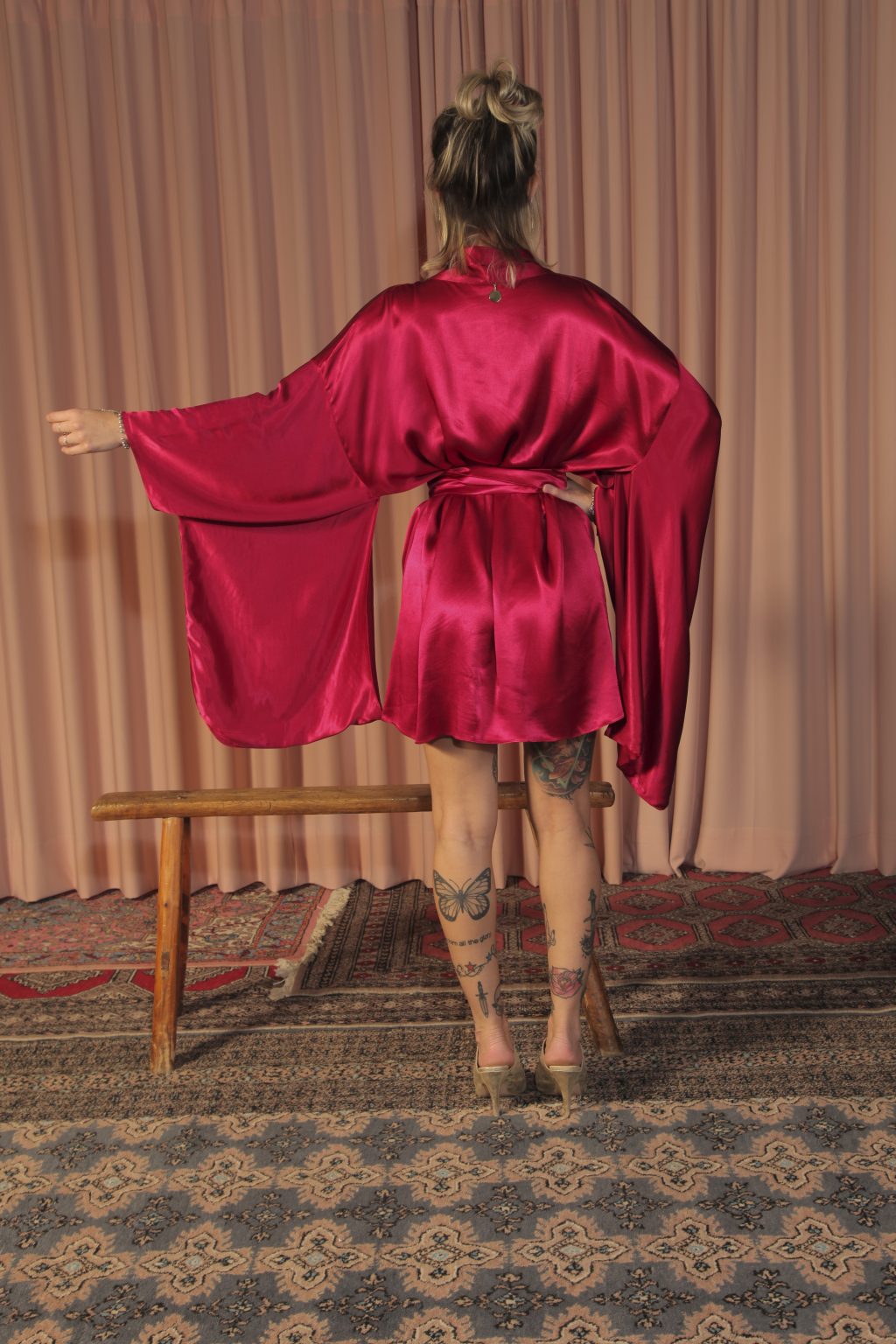 Mulher loira usando um kimono curto manga longa vermelho viscose faixa de amarração na cintura leveza elegância praticidade conforto maria sanz kimono quimono