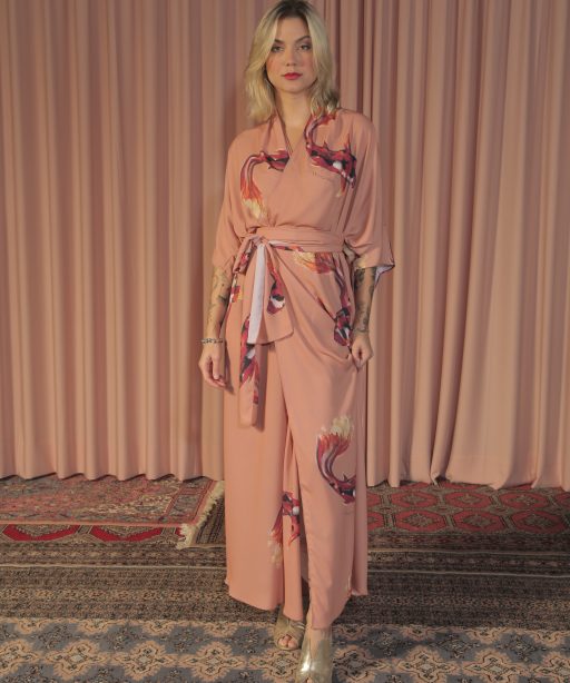 Mulher loira usando um kimono longo manga curta faixa de amarração na cintura estampa exclusiva nude com carpas desenvolvidas por maria sanz elegância praticidade conforto leveza kimono quimono