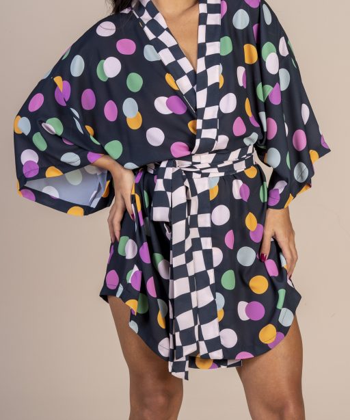 Mulher morena usando um kimono curto manga curta faixa para amarração na cintura estampa exclusiva preto com bolas coloridas joker conforto praticidade elegância maria sanz kimono quimono