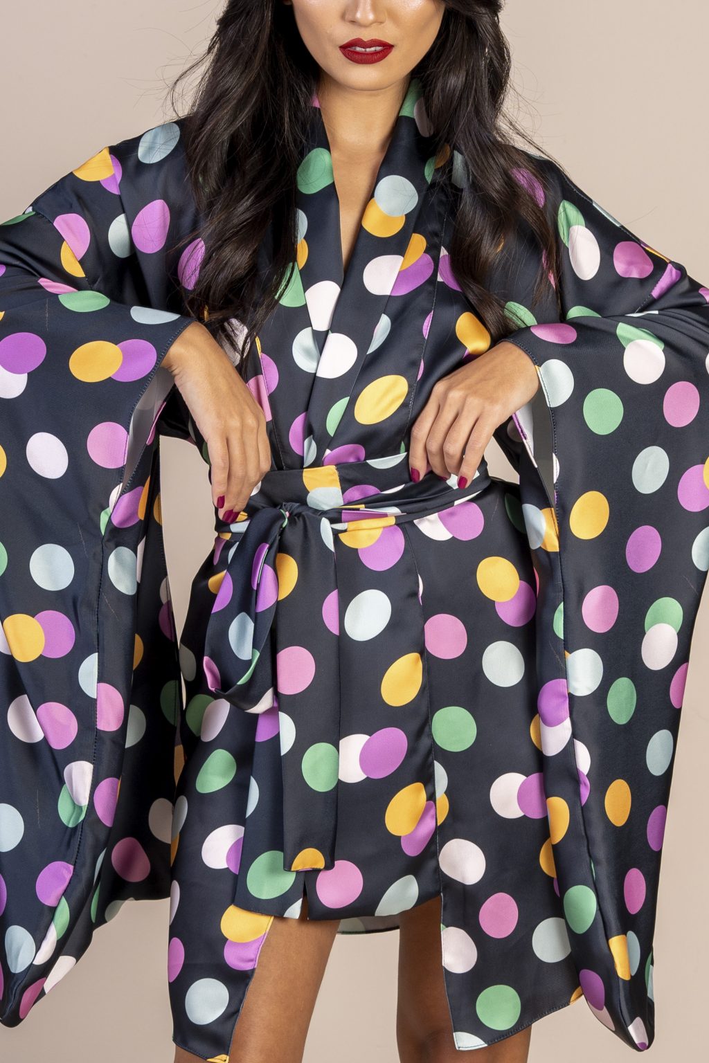 Mulher morena usando um kimono curto manga longo faixa para amarração na cintura estampa exclusiva preto com bolas coloridas conforto praticidade elegância joker maria sanz kimono quimono