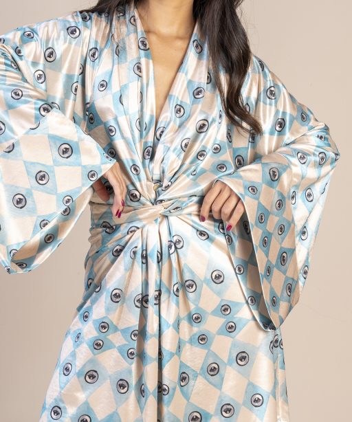 Mulher morena usando um vestido curto manga longa amarração na cintura estampa exclusiva losango bege e azul com olhos desenhados a mão exclusivo conforto elegância praticidade maria sanz kimono quimono joker