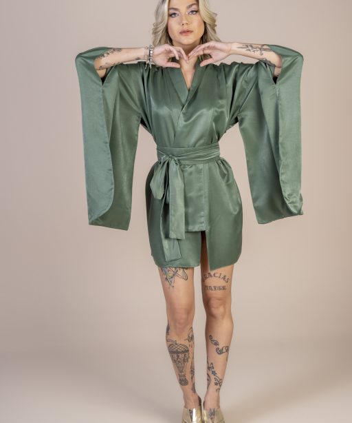 Mulher loira usando um kimono curto manga longa verde de viscose com bordado nas costas faixa para amarração na cintura exclusivo praticidade elegância conforto maria sanz kimono quimono