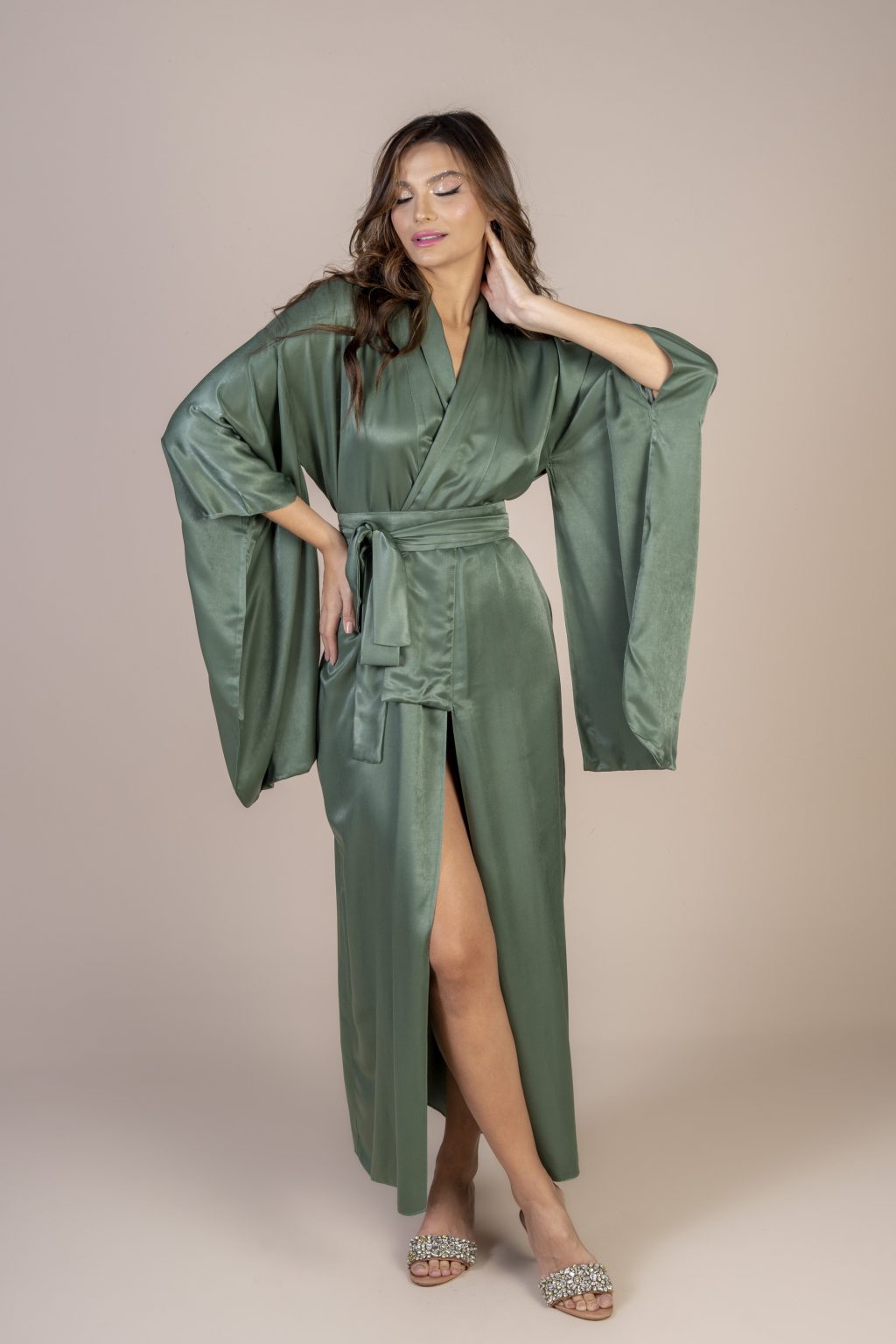 Mulher morena usando um kimono longo manga longa verde de viscose com bordado nas costas faixa para amarração na cintura exclusivo praticidade elegância conforto maria sanz kimono quimono