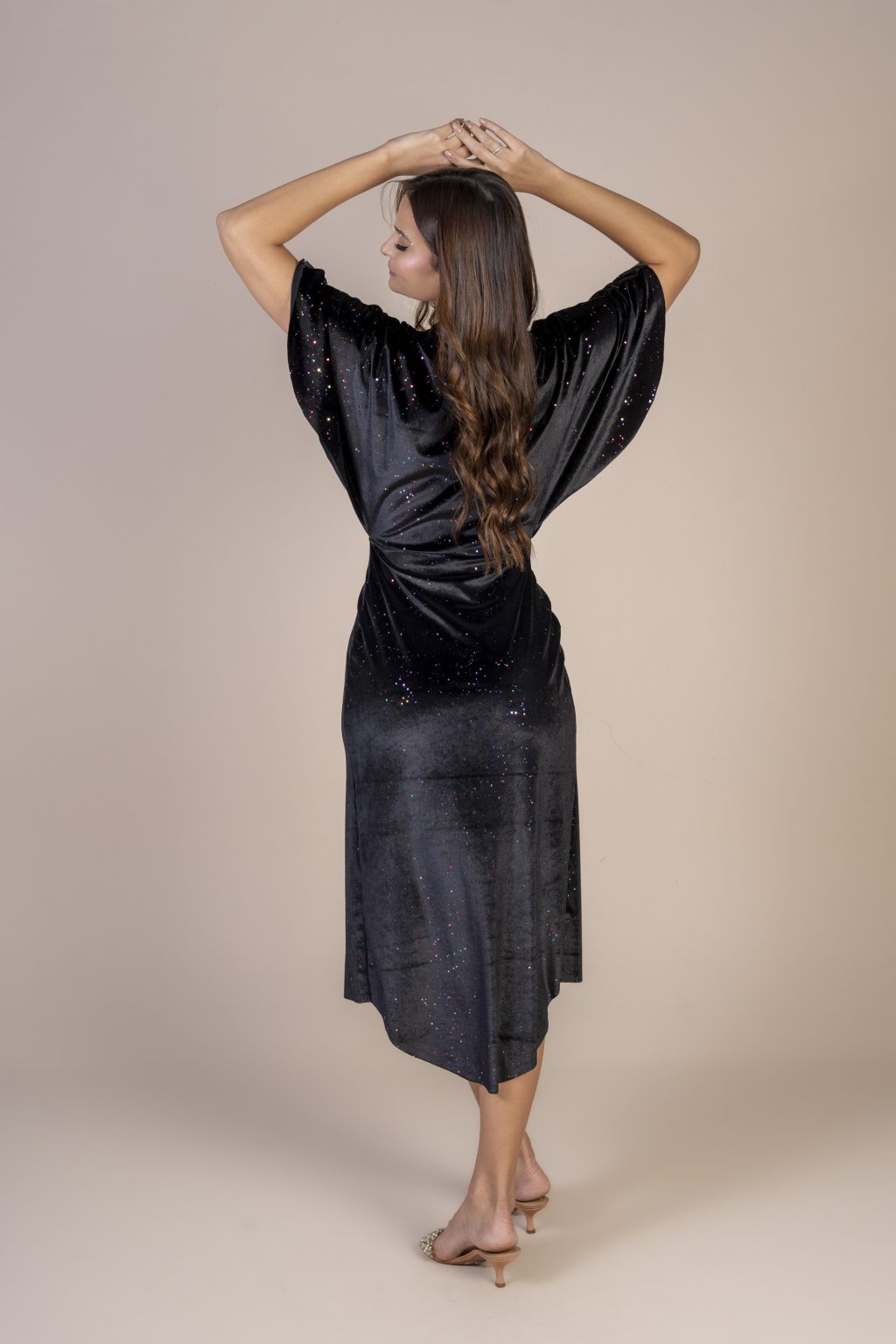 Mulher morena usando um vestido preto de veludo com brilho mídi manga curta com elástico na cintura conforto elegância praticidade edição limitada exclusiva maria sanz kimono quimono