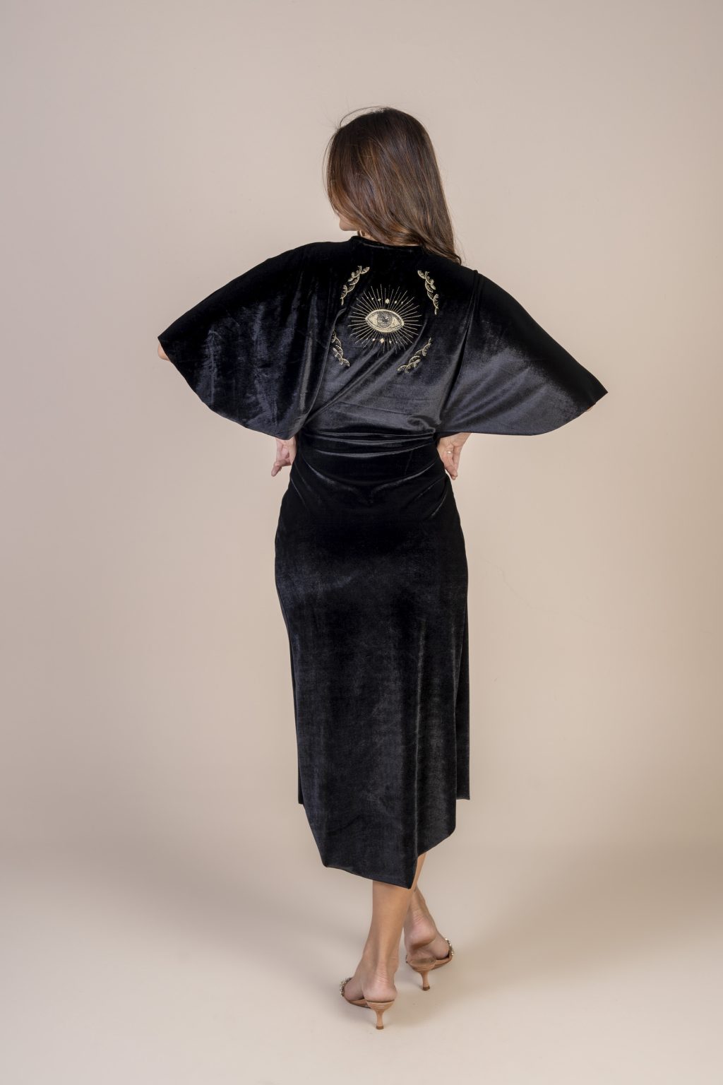 Mulher morena usando um vestido preto de veludo mídi manga curta com elástico na cintura bordado nas costas conforto elegância praticidade edição limitada exclusiva maria sanz kimono quimono