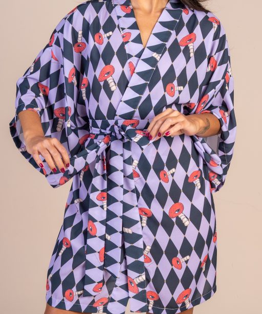 Mulher morena usando um kimono curto manga curta faixa de amarração na cintura estampa exclusiva de losango preto e lilas com cogumelos vermelhos com olhos desenhados a mão conforto praticidade elegância joker maria sanz kimono quimono